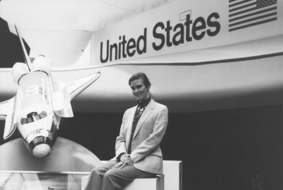 a black-and-white photo of Anita sitting in front of a spaceshuttle