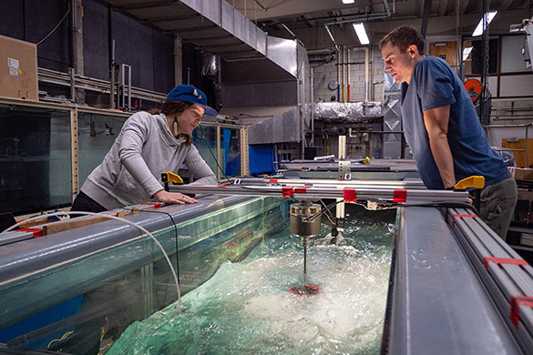 Two researchers conducting fluids research on the aerospace thermal lab