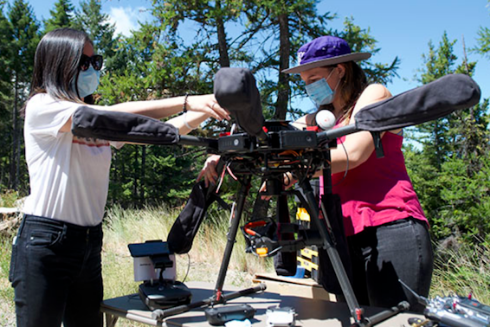 Two researchers putting together an aerial vehicle outdoors