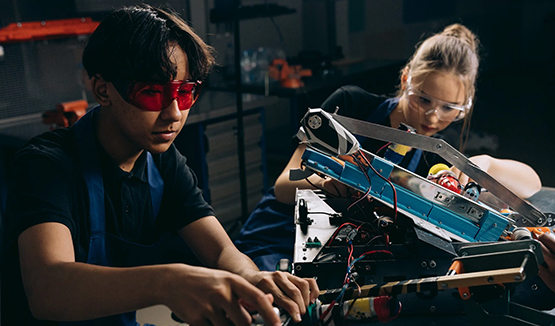 Two students working on a machine