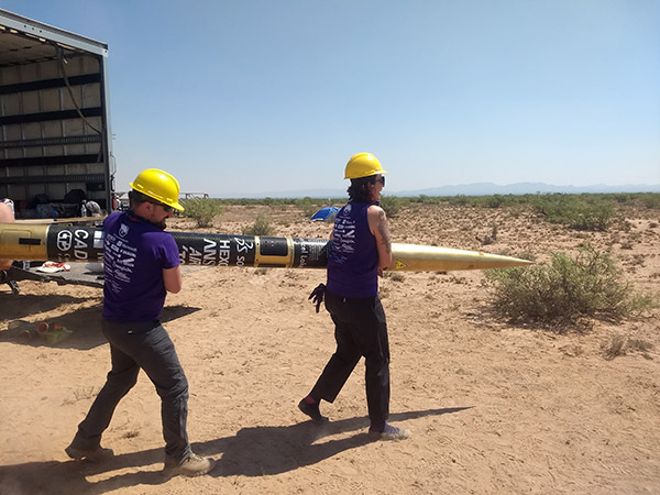 students carrying the rocket