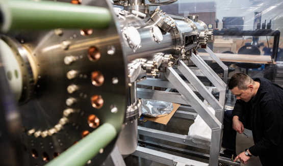 Man in a lab working on a fusion energy reactor