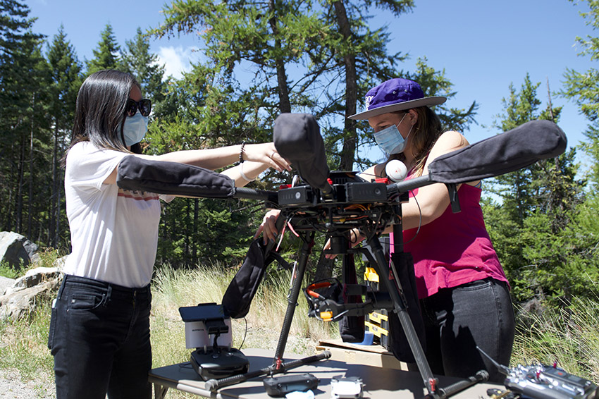 Two researchers putting together an aerial vehicle outdoors