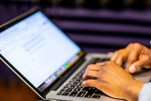 close up of hands typing on laptop keyboard