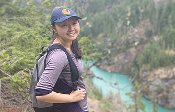 Sarah Li standing on a hill overlooking a river