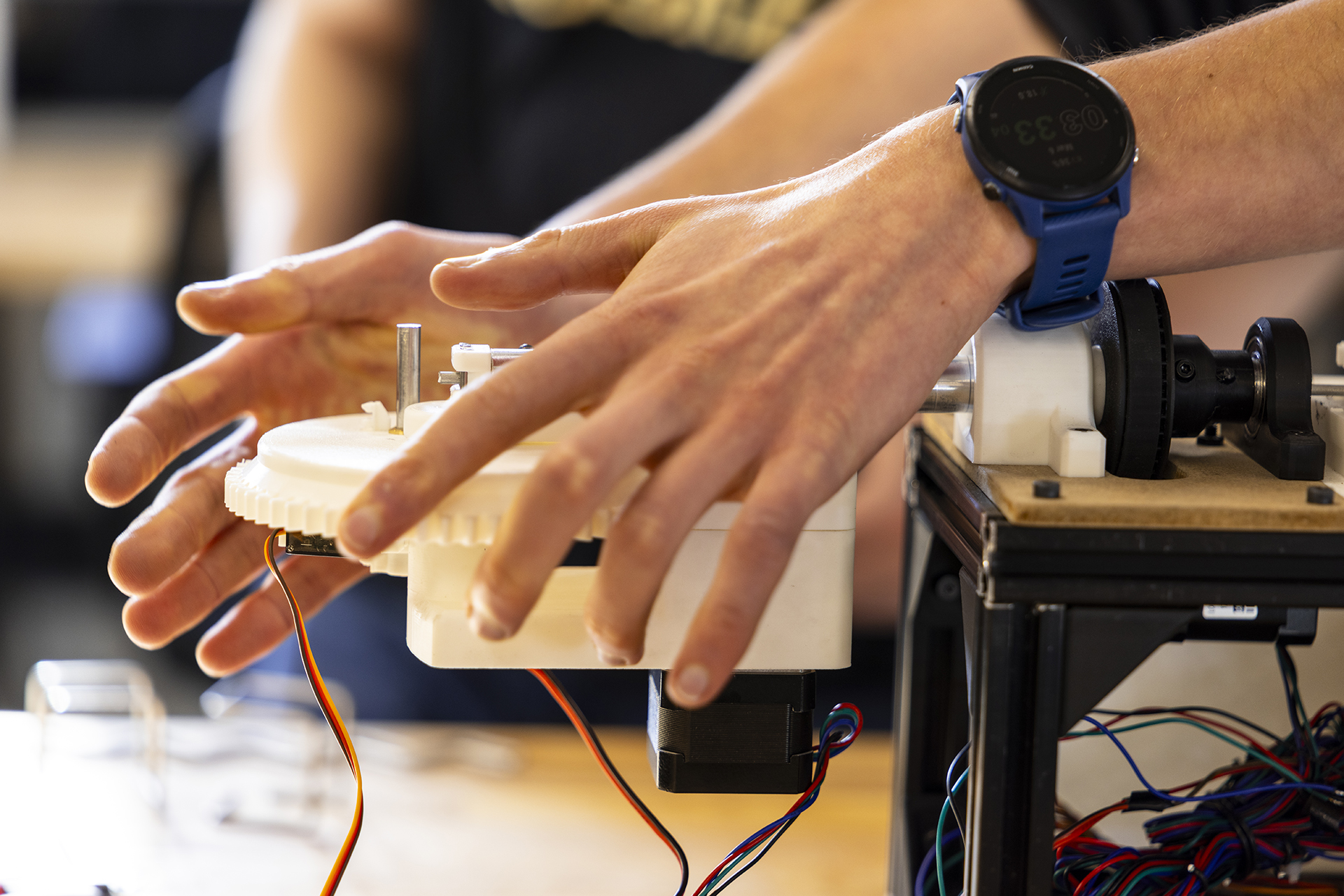 Hands adjusting a mechanical device