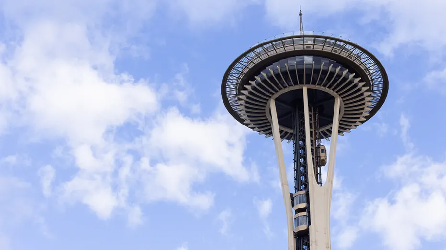 Space Needle against a blue sky with clouds.