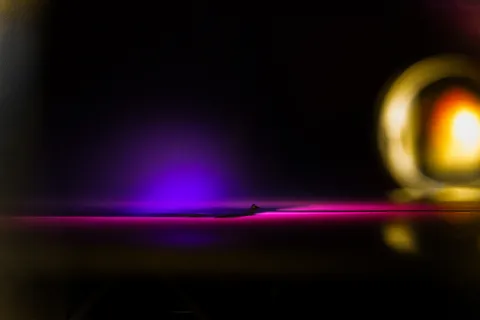 Glowing pink, purple and yellow bubbles against a black background