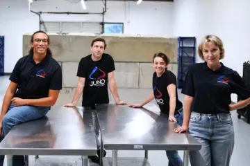 Four people around metal tables with Juno t-shirts.