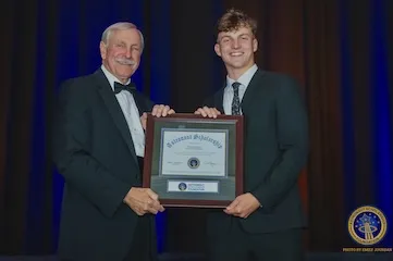 Mark receives a framed award from an astronaut.
